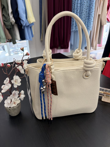 Bolso tote texturizado con asa de nudo elegante y detalle de dije